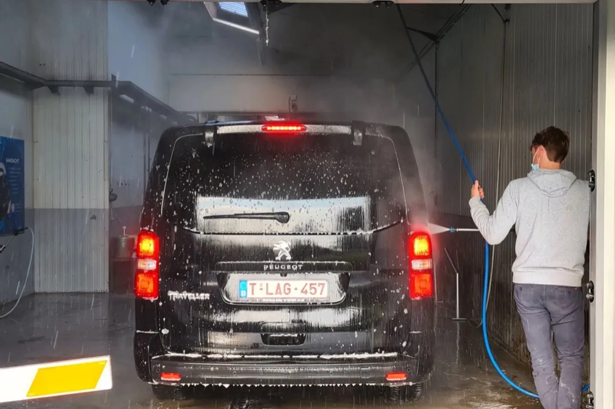 De vijf wasboxen van de selfcarwash, een wagen wordt met de hogedrukreiniger gewassen, avondlicht